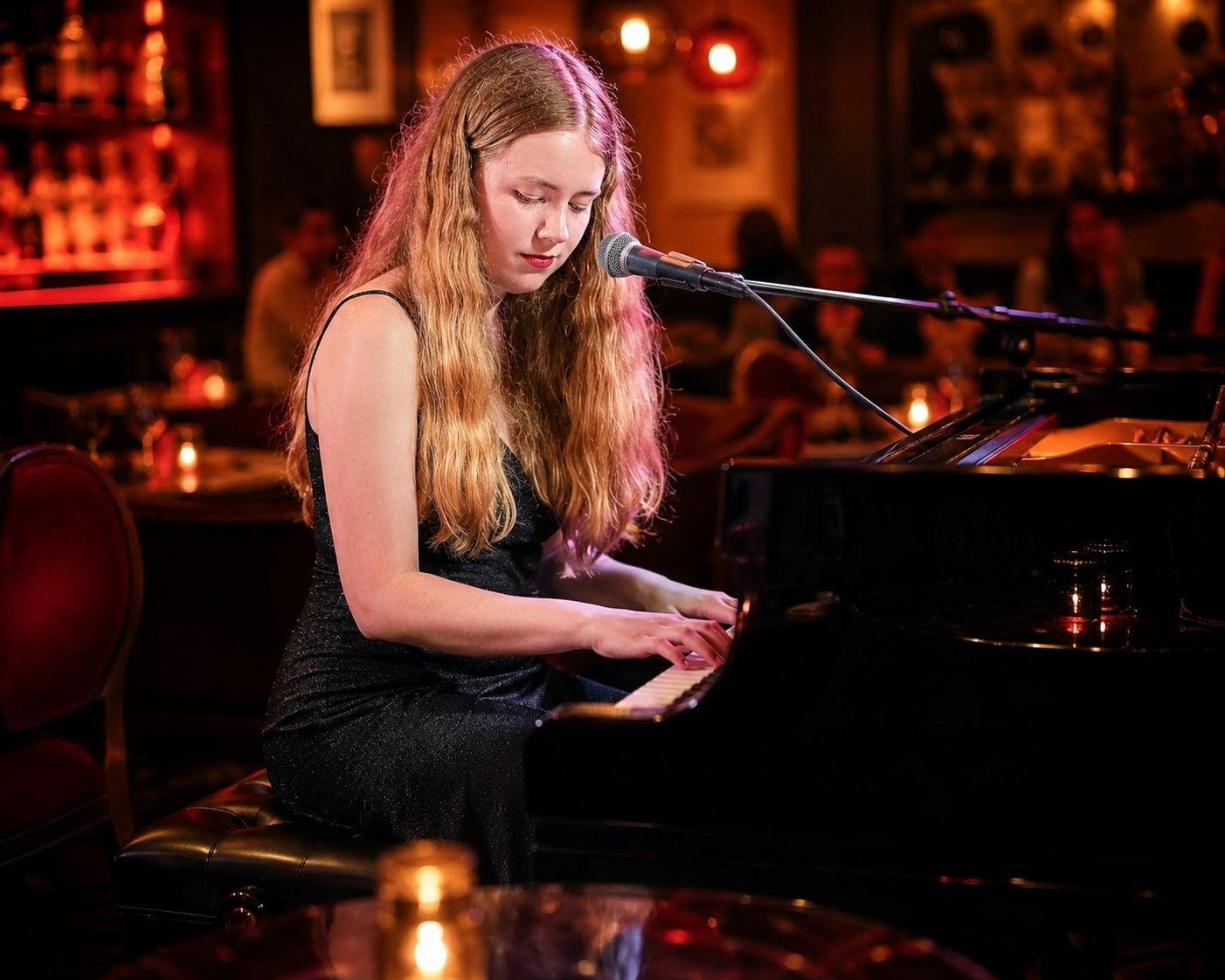 Jess Martyn singing at a grand piano in a candle-lit cocktail bar