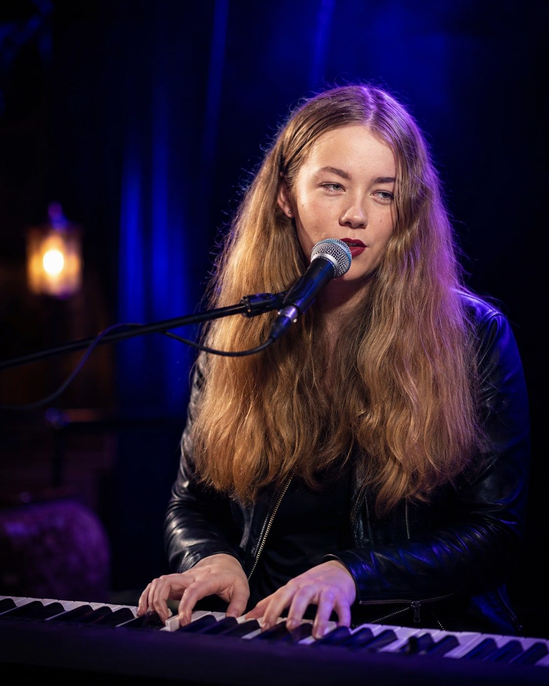 Jess Martyn singing at her keyboard under warm lounge lighting during a venue residency set