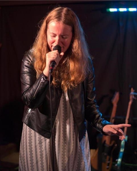Jess Martyn singing live with handheld microphone
