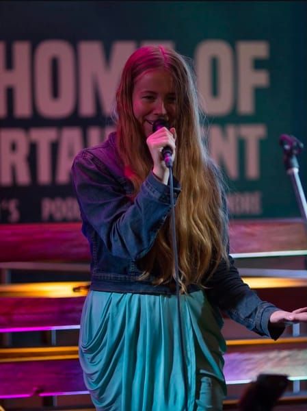 Jess Martyn singing live with a handheld microphone